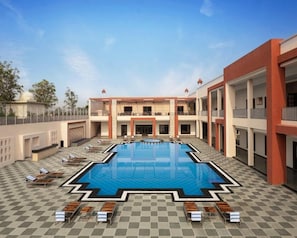 A hotel with a central swimming pool, sun loungers, and a covered outdoor area. - Bookmark Resort Jogi Mahal Ranthambore (Sawai Madhopur)