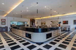 A modern hotel lobby with a check-in counter, seating area, and a patterned floor. - Bookmark Resort Jogi Mahal Ranthambore (Sawai Madhopur)