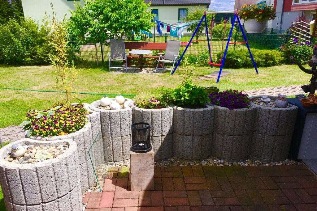 A garden with raised planters, a hammock, and a swing set.