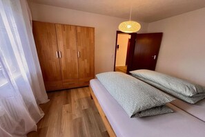 Une chambre à coucher avec un lit, une armoire et un luminaire suspendu.