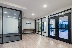 A modern interior with glass doors, a bench, and a view of an outdoor area. - Echo Suites Extended Stay by Wyndham Nashville/ Gallatin (Spartanburg)