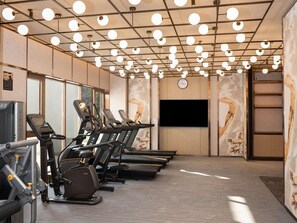 A fitness room with treadmills, a television, and a clock on the wall. - Dangkou Ancient Town Hotel Wuxi - Mgallery Collection (Suzhou)