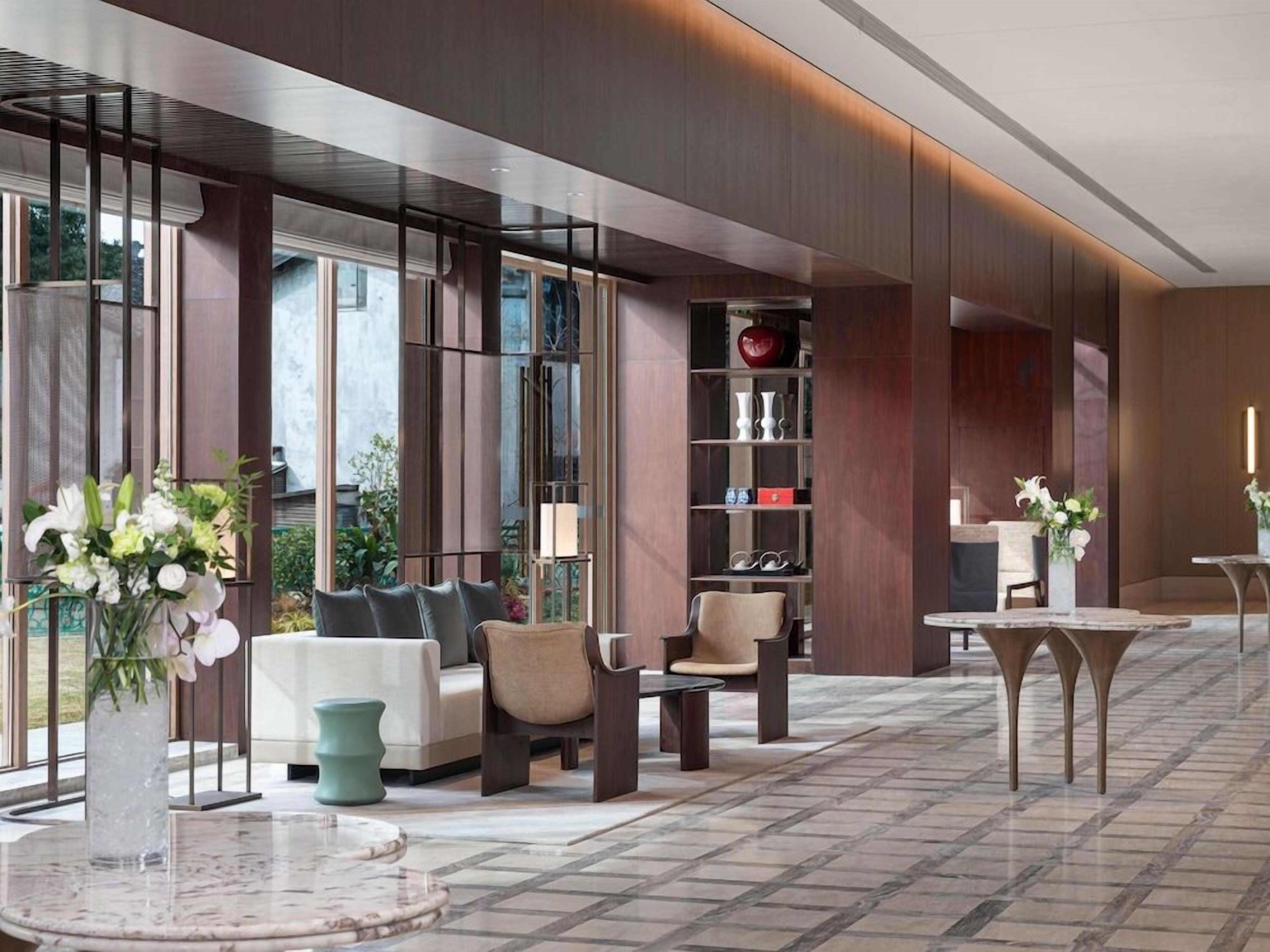 A modern lobby with seating, a coffee table, and a bookshelf.