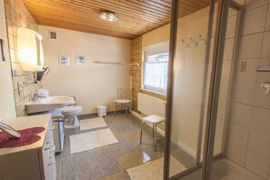 Une salle de bain équipée d’une douche, de toilettes, d’un lavabo et d’un miroir.