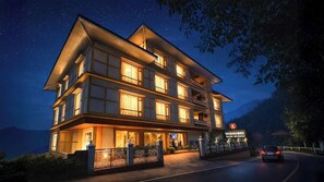 A multi-story hotel with a balcony on the second floor, a signboard with the name 'YASHISHREE,' and a view of the mountains in the background. - Yashshree Sikkim Blossom (Gangtok)