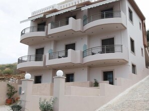 A multi-story residential building with balconies, a flat roof, and a gated entrance. - Aenaon Apartments (Nafplio)