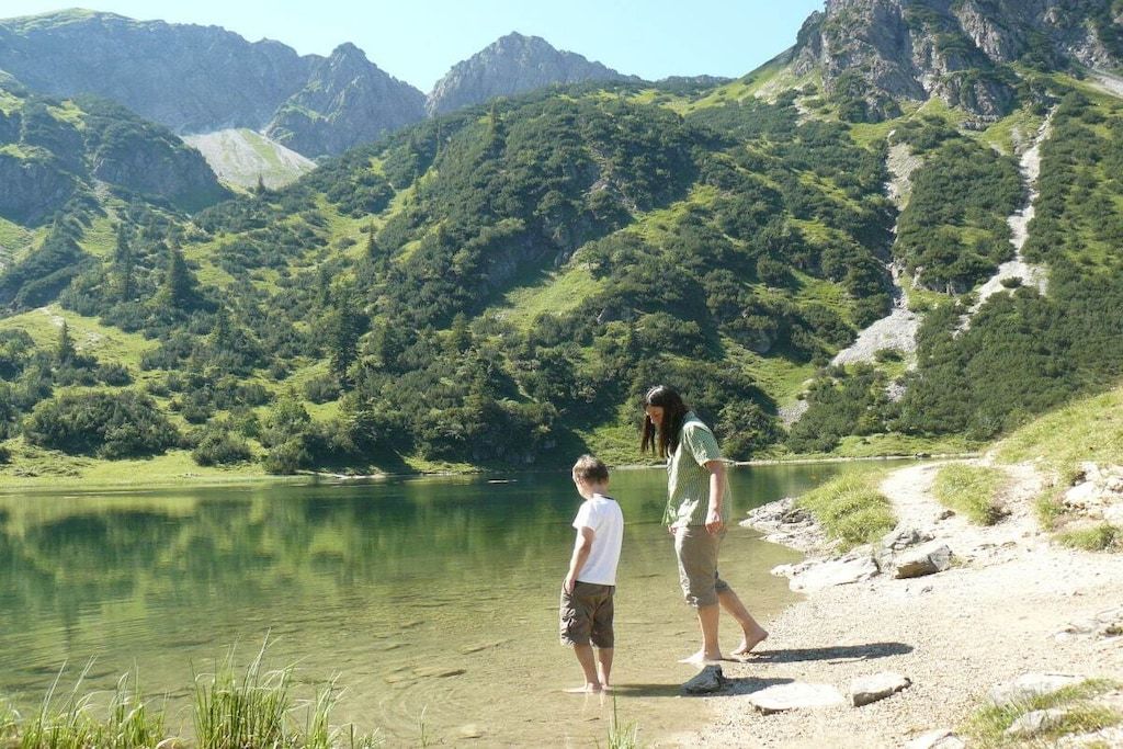 A natural landscape with a lake, mountains, and a clear sky.