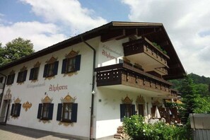 En traditionel bygning i alpe-stil med en balkon og skiltning, der angiver, at det er et hotel.