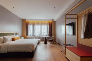 A hotel room with a bed, a round table, a TV, and a seating area. - Breakx Hotel Penang (George Town)
