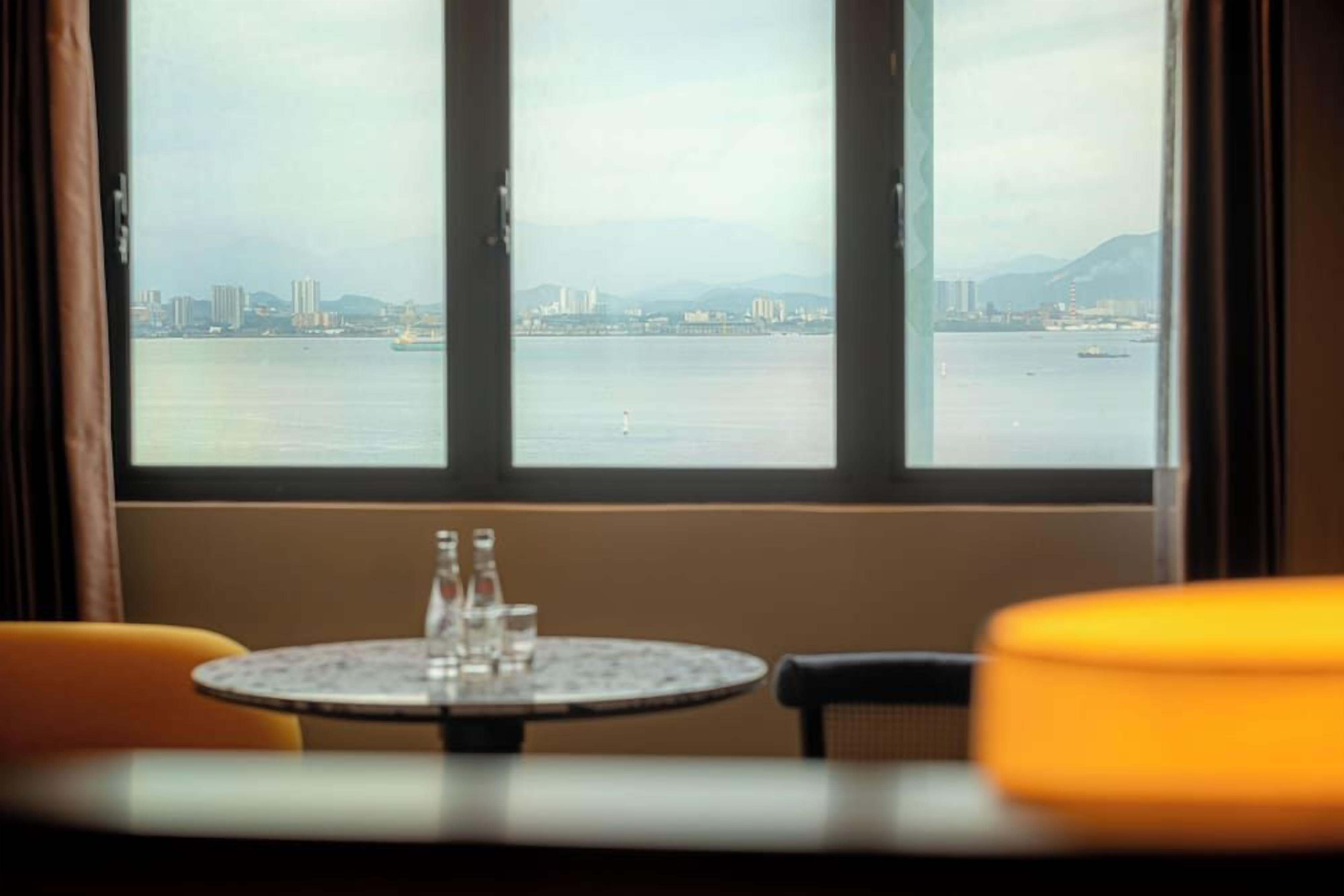 A table with a view of a cityscape through a window.