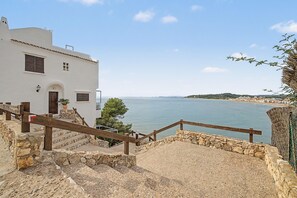 A coastal building with a stone staircase leading to a wooden railing overlooking the sea. - Studio 'Escapada en Pareja en Altafulla' with Pool, Wi-Fi and Air Conditioning (Altafulla)
