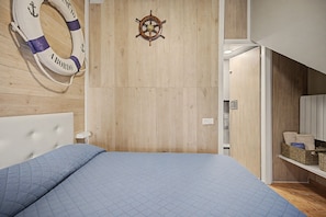 Ein Schlafzimmer mit einem Bett, einem Rettungsring und einem Schiffsrad an der Wand.