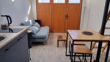 Une cuisine compacte avec un coin repas, un canapé et une petite table.