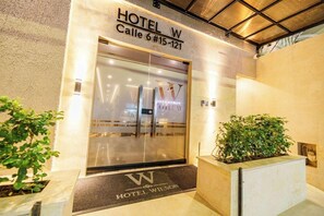 The entrance to HOTEL W, Calle 6 #15-121, with a glass door and a doormat. - Hotel W Santa Marta (Santa Marta)