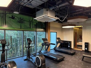 A gym with treadmills, stationary bikes, and a wall mural. - Hotel Gafsacomm Tulum Aeropuerto (Mérida)