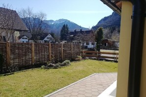 A view of a residential area with a wooden fence, a grassy lawn, and houses in the background. - Holiday apartment with 2 bedrooms (Oberammergau)
