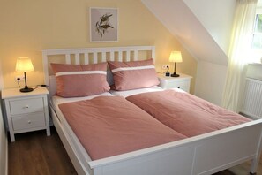 A bedroom with a white bed, two bedside tables, and a nightstand. - Holiday apartment with 2 bedrooms (Oberammergau)
