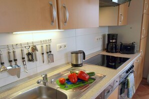 A kitchen with stainless steel appliances, a coffee maker, and a toaster. - Dune grass with balcony (Dahme)
