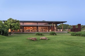 A modern building with a covered outdoor seating area, a well-maintained lawn, and a clear sky. - Woods At Sasan (Mendarda)