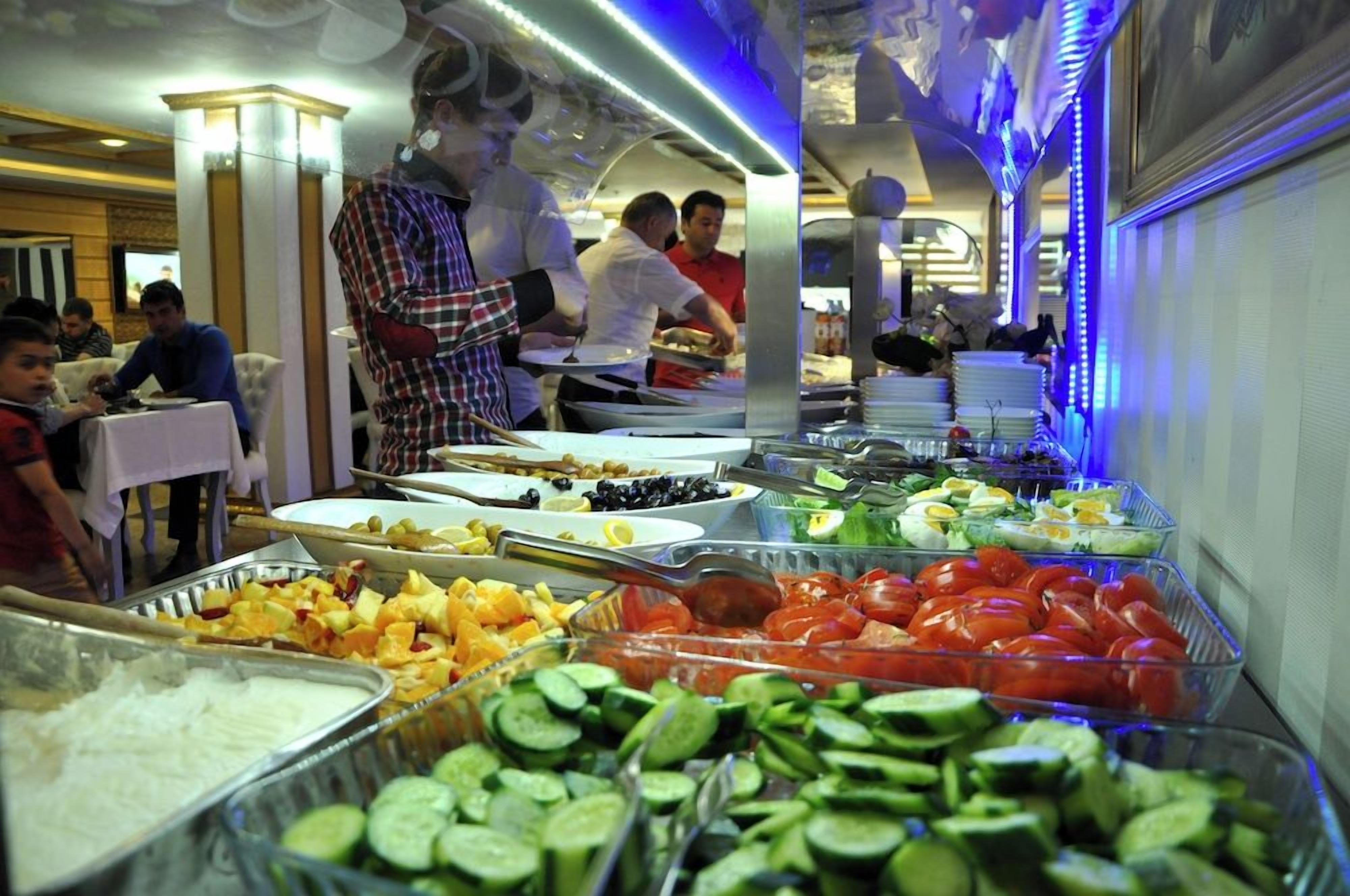 Un bufé con diversos alimentos, entre ellos frutas, verduras y platos ya preparados.