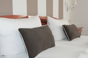 A bed with white and brown pillows, a wooden headboard, and a bedside table with a lamp. - Villa Steinfurth Ap 1 (Ostseebad Binz)