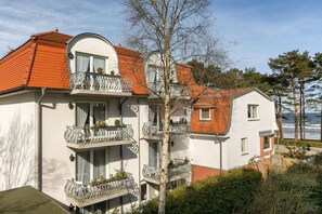 A multi-story building with balconies, a curved roof, and a view of the sea. - Villa Steinfurth Ap 1 (Ostseebad Binz)