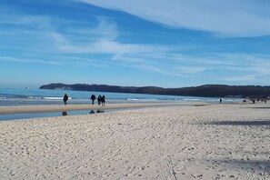 A sandy beach with footprints, a clear sky, and a distant shoreline. - Villa Steinfurth Ap 1 (Ostseebad Binz)