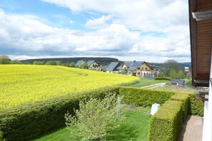 A residential area with houses, a field of yellow crops, and a hedge. - Holiday apartment with 1 bedroom (Annaberg-Buchholz)