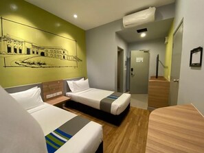 A hotel room with two beds, a wooden headboard, a wall mural, and a wooden floor.