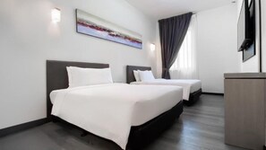 A hotel room with two beds, a flat-screen TV, a painting on the wall, and a window with curtains. - Kingston Hotel 16 AT Legoland Johor Bahru (Gelang Patah)