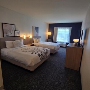 A hotel room with two beds, a desk, a chair, a TV, and a window with curtains. - Spark by Hilton Harrisburg East (Harrisburg)