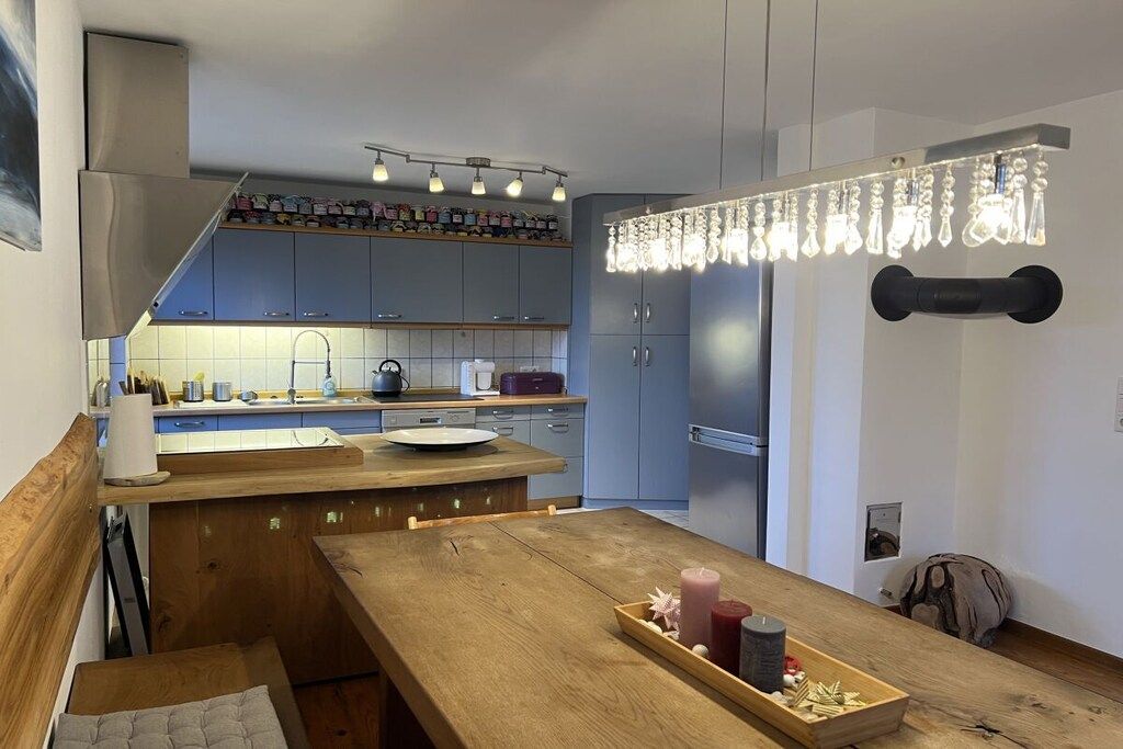A modern kitchen with a wooden island, built-in cabinets, and pendant lighting.
