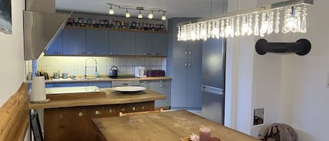 A modern kitchen with a wooden island, built-in cabinets, and pendant lighting.