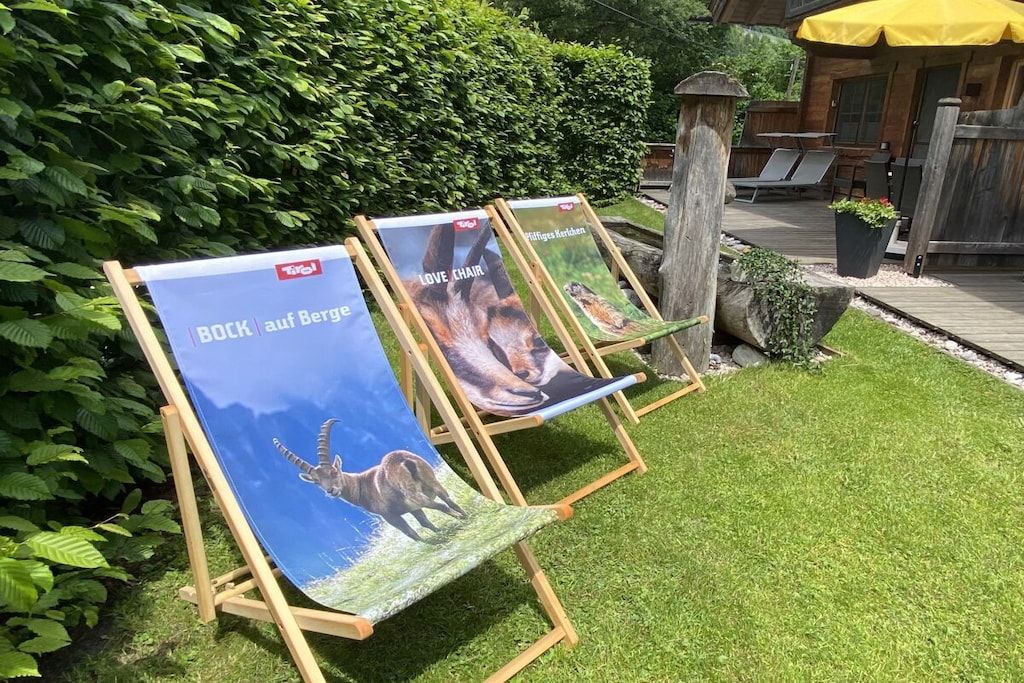 Three easels with posters in a garden setting.