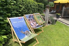 Tres caballetes con carteles en un jardín.