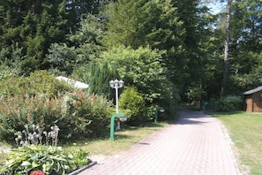 Ein gepflasterter Weg in einem Garten mit einer Laterne und verschiedenen Pflanzen.