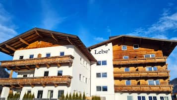 Un immeuble à plusieurs étages, doté d’une façade en bois et de balcons, portant l’inscription « Lebe ».