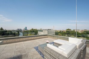 Eine Dachterrasse mit Blick auf einen Fluss, Gebäude und einen klaren Himmel.