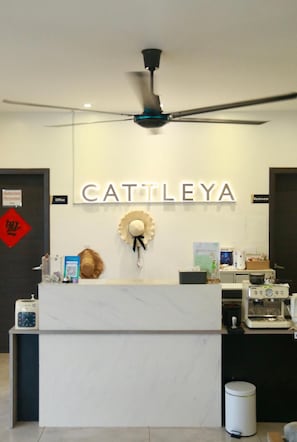 A reception area with a ceiling fan, a sign reading 'CATTLEYA,' and a counter with various items. - Bohol Cattleya Resort (Panglao)
