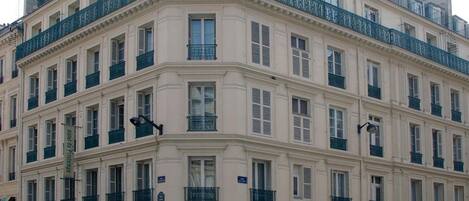 Un immeuble à plusieurs étages, de style architectural classique, doté de balcons et d’une façade uniforme.