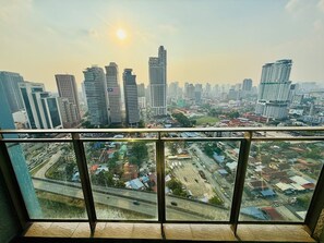 A cityscape viewed from a balcony with modern buildings and a highway in the foreground. - Mercu summer suites by premium charter  (Kuala Lumpur)