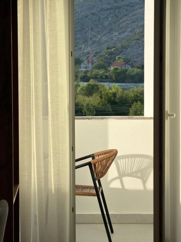 A room with a view of a mountainous landscape through a window.