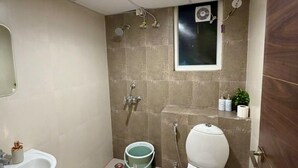 A small bathroom with a toilet, sink, and shower. - Slate VII by Ved Homes (Jaipur)