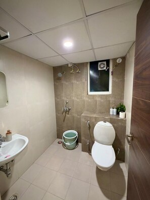 Ein kleines Badezimmer mit Toilette, Waschbecken und Dusche.