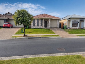 A residential street with houses, a tree, and a parked car. - Relaxing Gateway: Private Room 1 (North Lakes)
