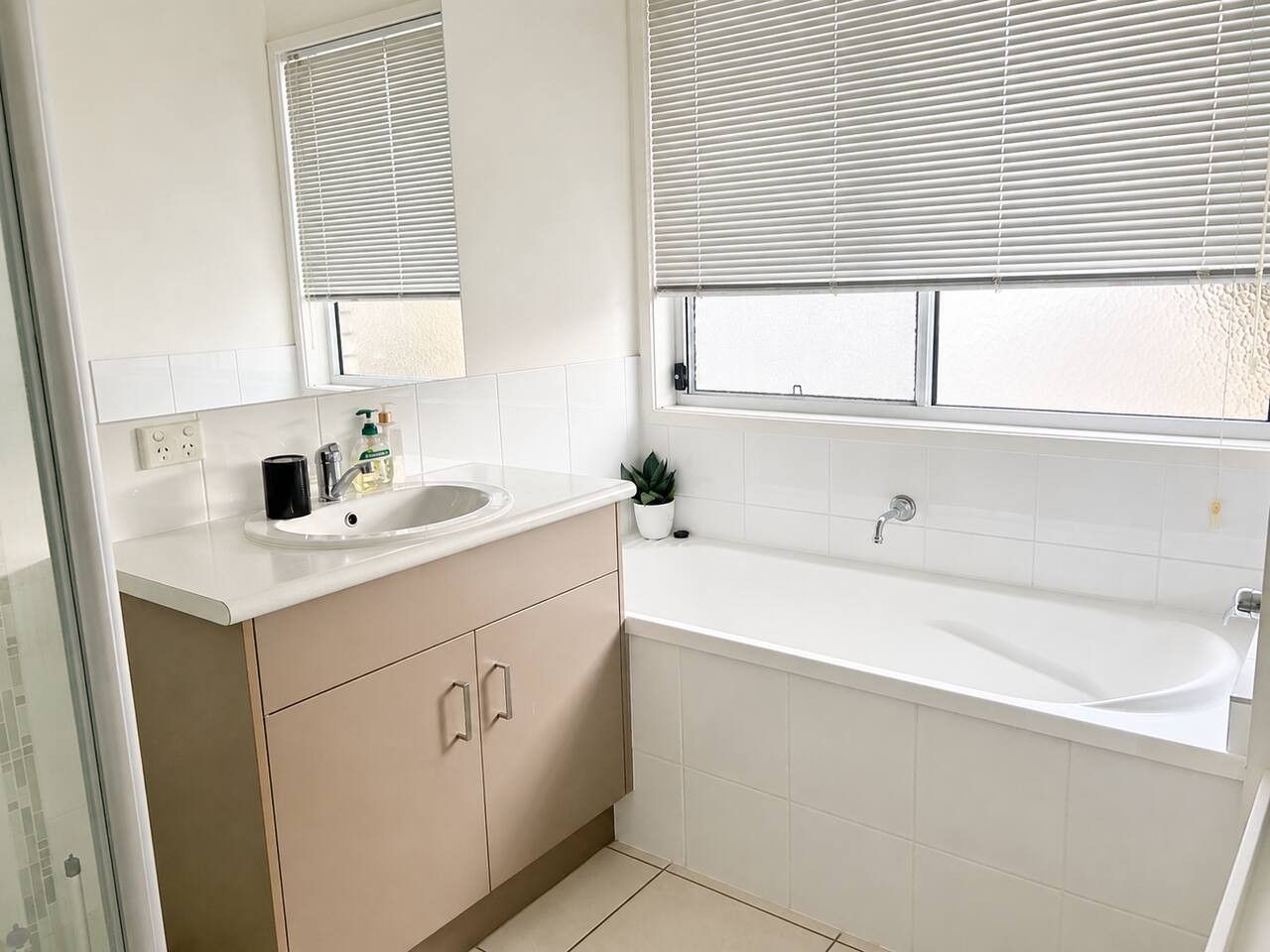 Une salle de bain moderne avec un lavabo, un miroir et une baignoire.