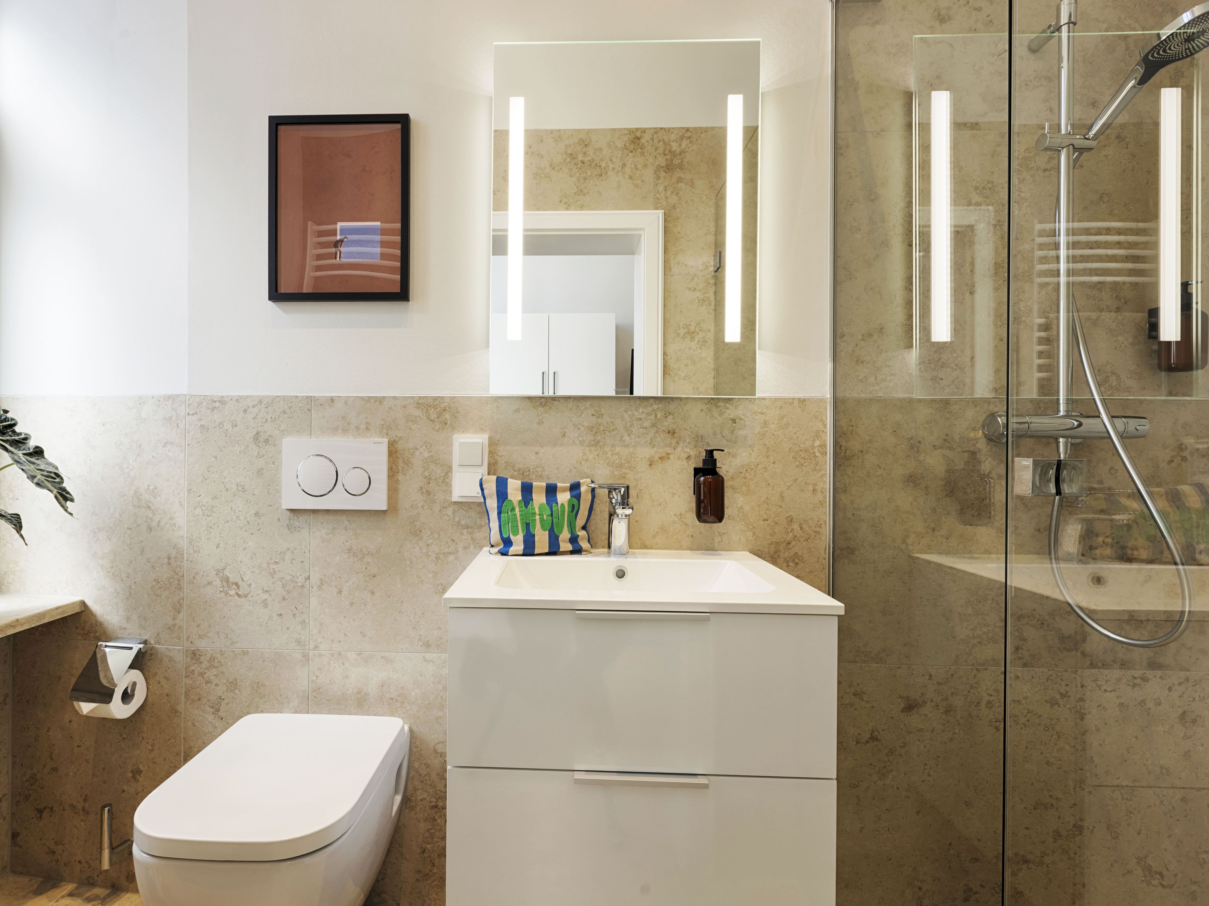 Ein modernes Badezimmer mit Toilette, Waschbecken und Dusche.