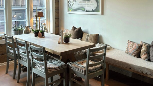 A dining area with a wooden table, chairs, and a bench.