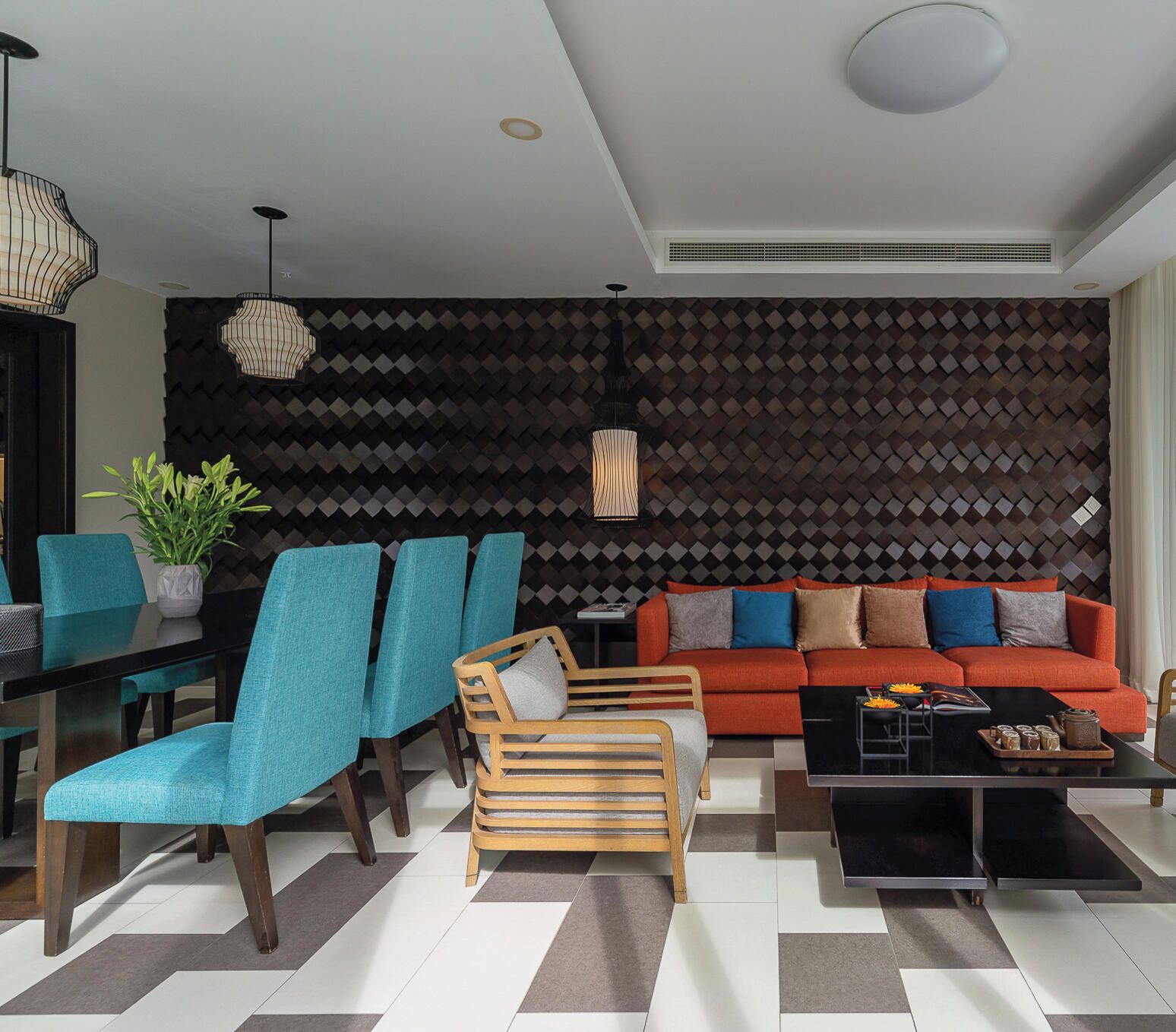 A modern living room with a sofa, chairs, a coffee table, and a patterned wall.