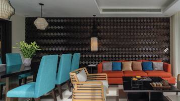 A modern living room with a sofa, chairs, a coffee table, and a patterned wall.
